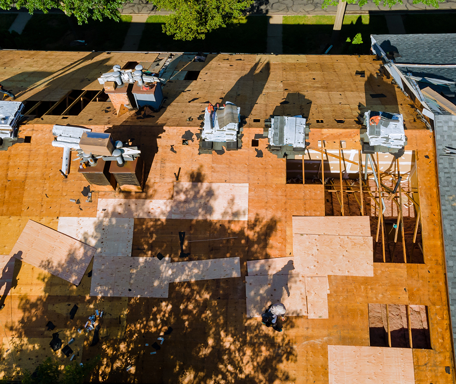 Professional roofers repairing holes in roof