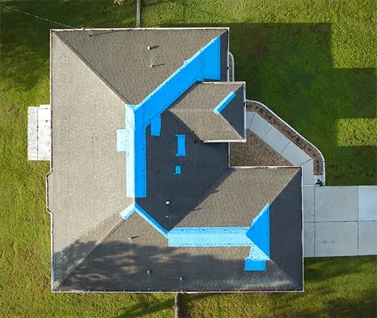 Birds-eye-view of a home with emergency tarping on roof 