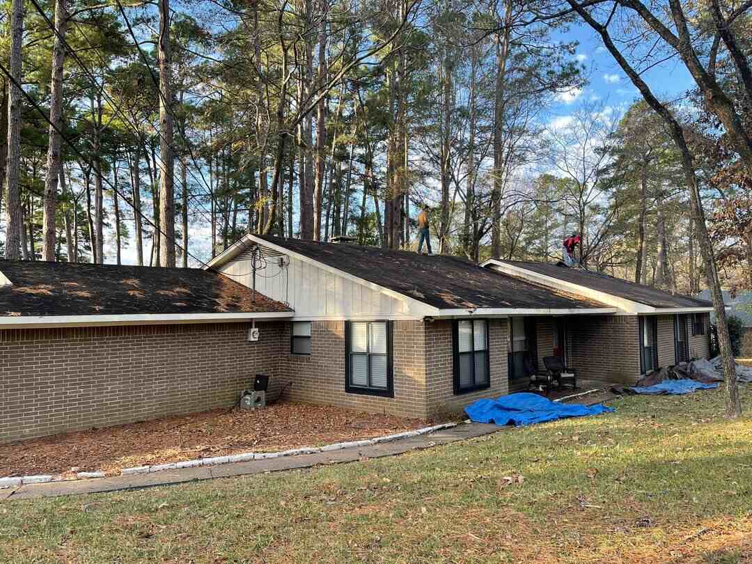 home with debris on the roof from the nearby trees